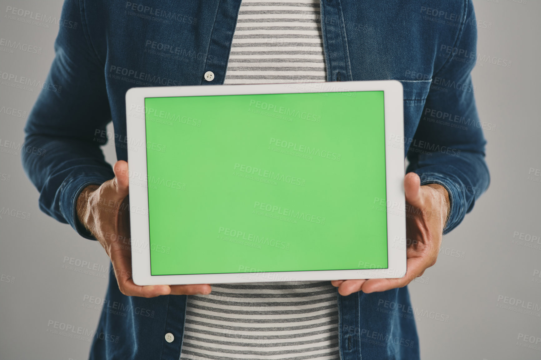 Buy stock photo Studio shot of an unrecognisable man holding a digital tablet with a green screen against a grey background