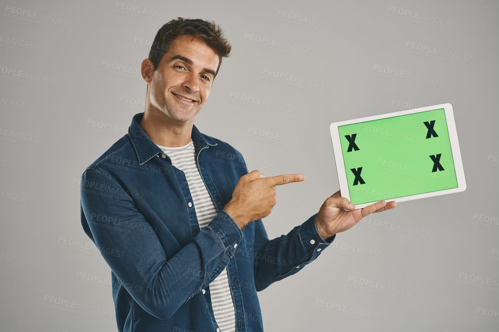 Buy stock photo Portrait, green screen and man with tablet, pointing and happy person on gray studio background. Face, guy and model with tech, tracking markers and social media with internet, gesture and connection