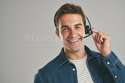 Buy stock photo Studio portrait of a young man wearing a headset against a grey background