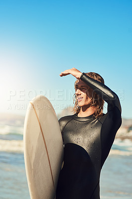 Buy stock photo Shot of a handsome young man at the beach with his surfboard