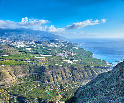 Buy stock photo Above of an agricultural landscape on an island with a blue sky with copy space. Aerial view of farm land with lush green grass, a harbor and banana plantations in Los Llanos, La Palma, Spain