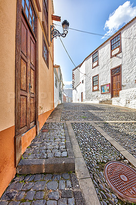 Buy stock photo Scenic view of old historic houses, residential buildings, traditional infrastructure in cobblestone alleyway in a city street or road. Travel destination in Santa Cruz, La Palma, Spain