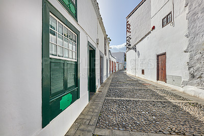 Buy stock photo Scenic view of old historic houses, residential buildings, traditional infrastructure in cobblestone alleyway, street, road. Tourism abroad, overseas travel destination in Santa Cruz, La Palma, Spain