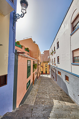 Buy stock photo Narrow street with colorful houses and a blue sky. Architecture of tiny walk way between old townhouse buildings. Empty lane in a beautiful city for exploring and sightseeing, Santa Cruz de La Palma