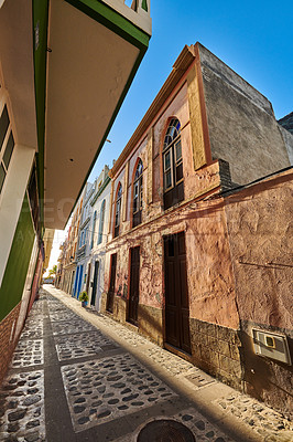 Buy stock photo Old buildings in a vintage city built by traditional architecture in a small town or village. Houses or homes with an antique design close to each other outdoors on a summer afternoon with a blue sky