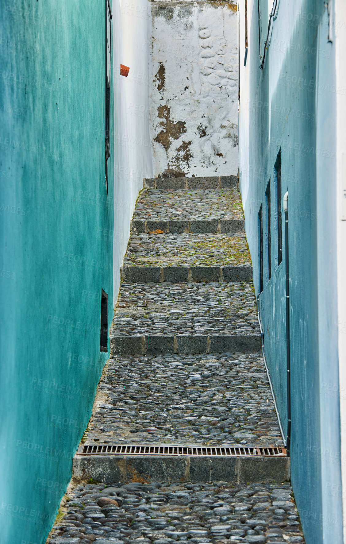 Buy stock photo Narrow cobblestone street staircase architecture in a historic city. Empty stone alleyway road between two vibrant residential buildings. Travel and tourism abroad in Santa Cruz, La Palma, Spain