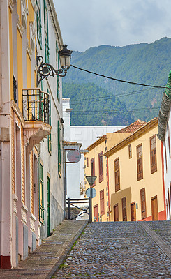 Buy stock photo Narrow street or alley between colorful buildings in Santa Cruz, de La Palma. Bright and vibrant classical architecture in a small city or village. Beautiful houses or homes with a vintage design