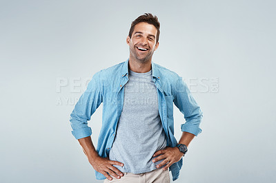 Buy stock photo Portrait of a cheerful young man smiling brightly while standing against a grey background