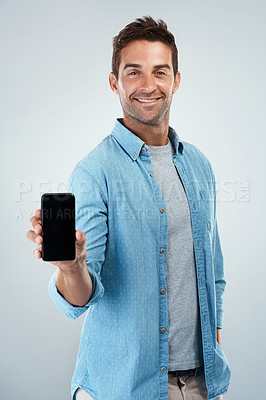 Buy stock photo Advertising, phone screen and portrait of casual man in studio on white background for communication. App, smile and social media marketing with happy person showing mobile display for networking