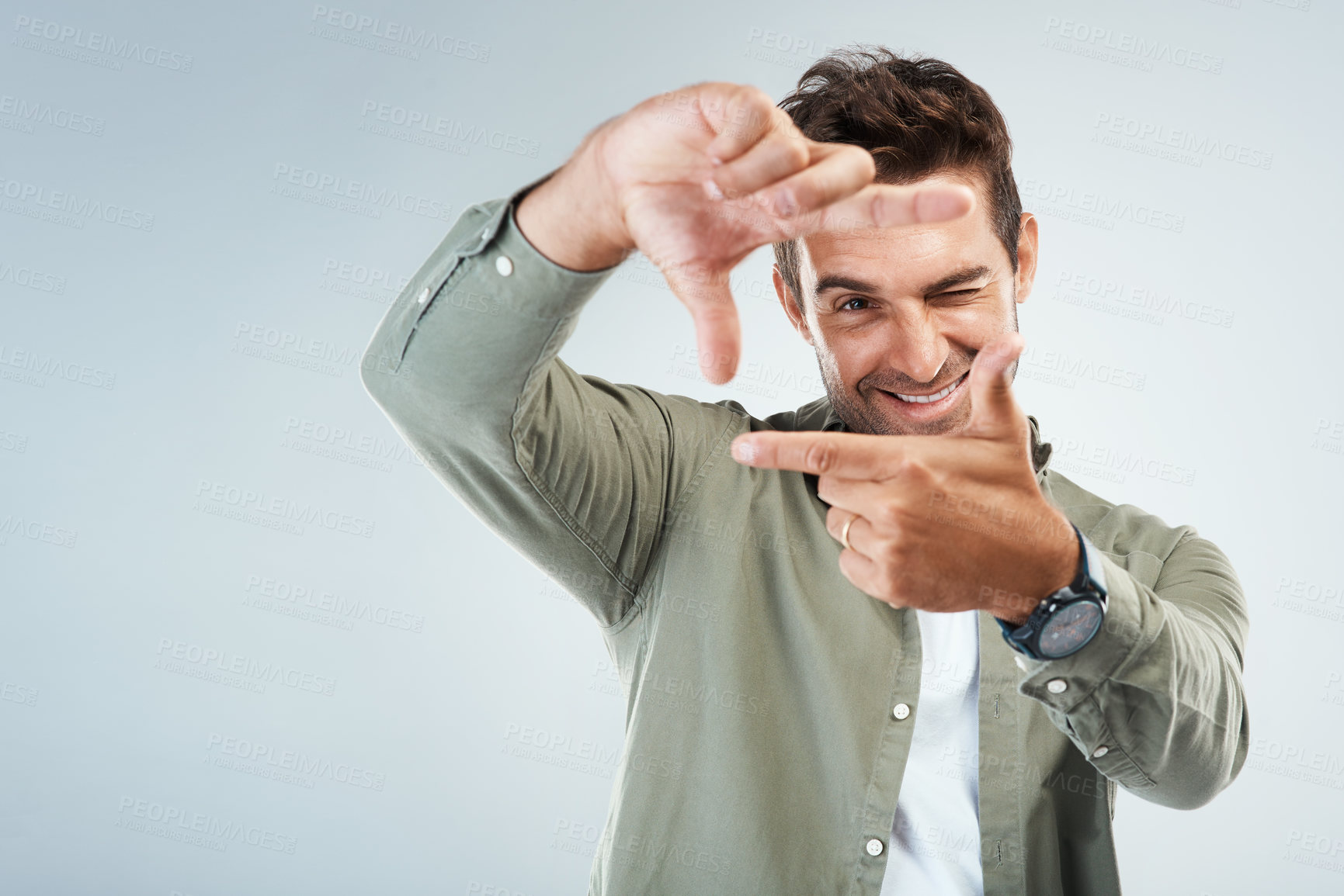 Buy stock photo Hands, frame and portrait of man in studio with sign for photo, photography or fun picture. Face, male person and influencer on gray background with finger border, selfie smile or wink for confidence