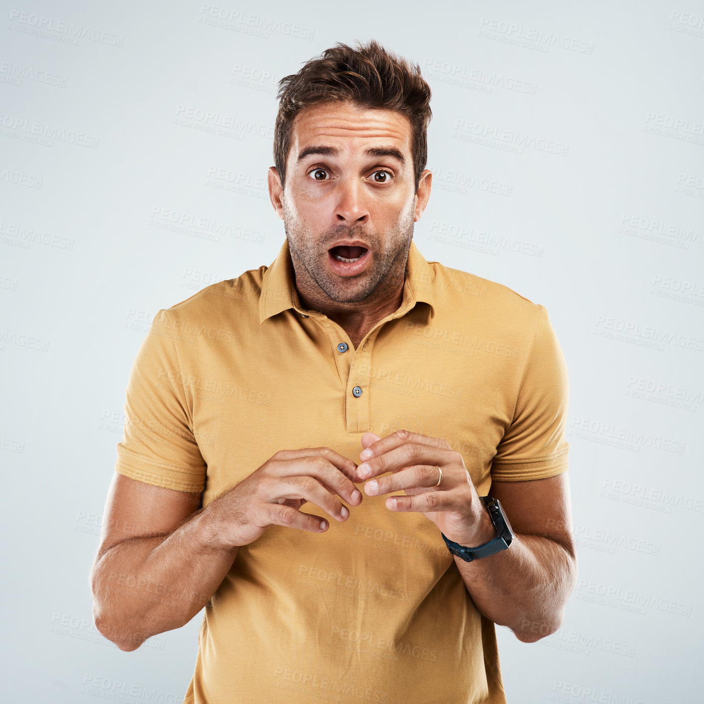 Buy stock photo Portrait of a young man with a scared facial expression while standing against a grey background