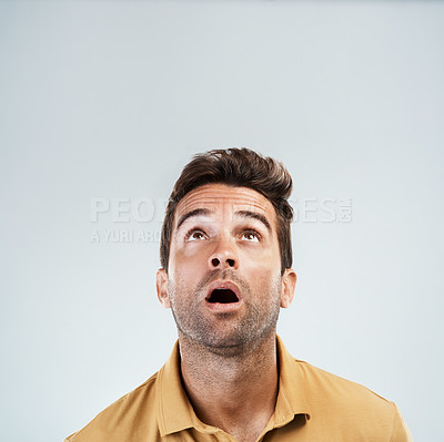 Buy stock photo Studio shot of a young man with a confused facial expression while standing against a grey background