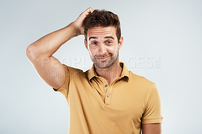 Buy stock photo Portrait of a young man with a confused facial expression while standing against a grey background