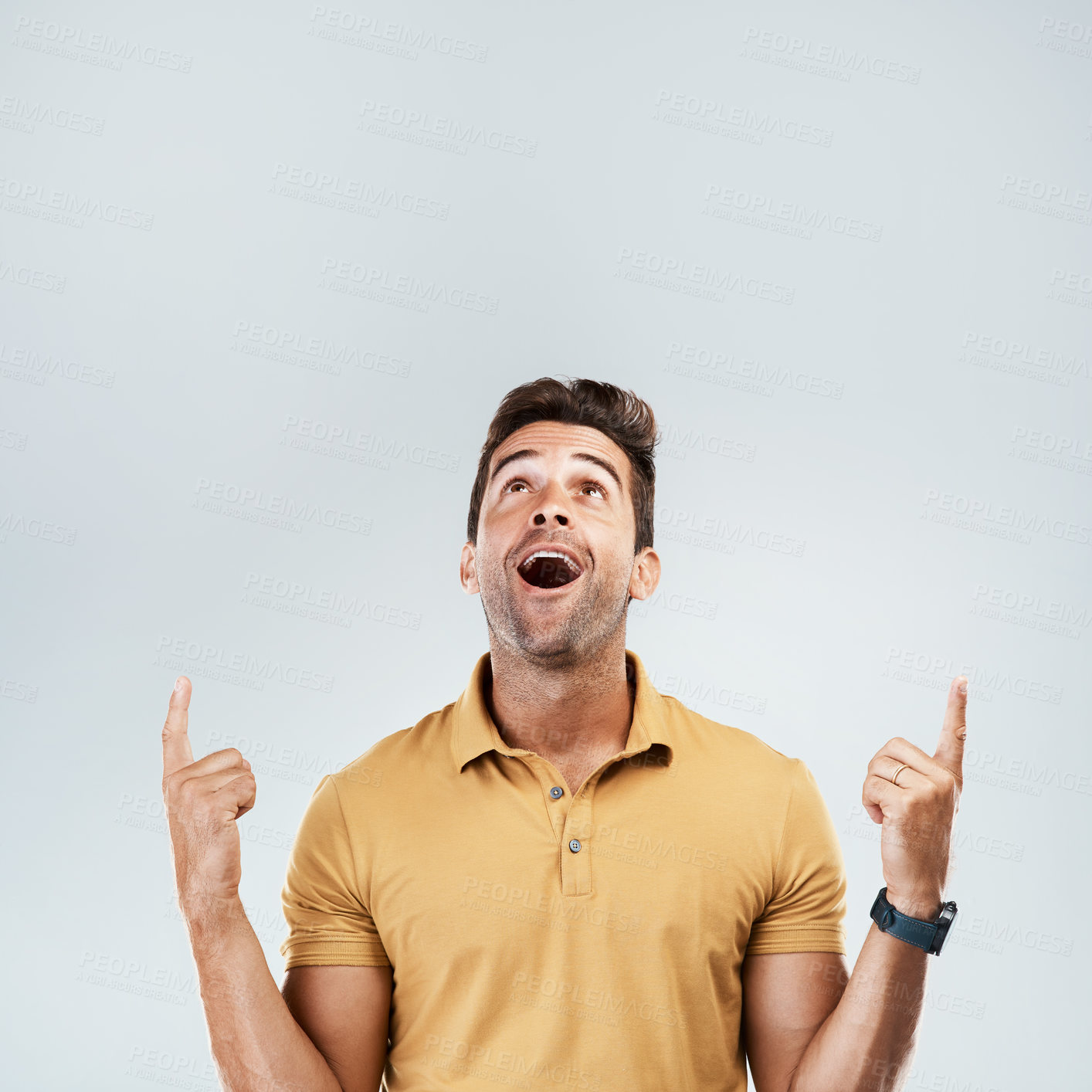 Buy stock photo Man, pointing and happy on studio mockup for deal, promotion and coming soon. Male promoter, wow and up hand gesture on gray background space for announcement, information and excited for opportunity