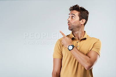 Buy stock photo Man, pointing and shocked on studio space for deal, promotion and coming soon. Male promoter, what and hand gesture on gray background mockup for announcement, information and excited for opportunity