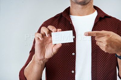 Buy stock photo Studio shot of an unrecognizable man holding and displaying a business card while standing against a grey background