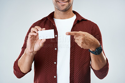 Buy stock photo Studio shot of an unrecognizable man holding and displaying a business card while standing against a grey background