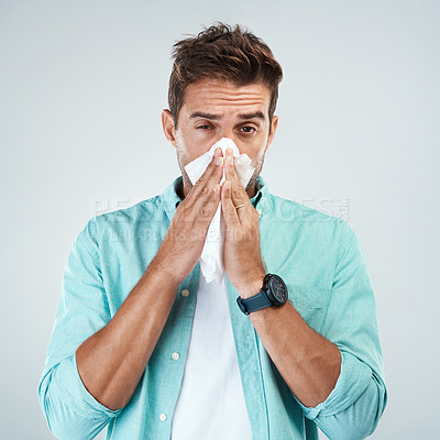Buy stock photo Sick, tissue and portrait of man blowing nose in studio with flu, illness and virus on white background. Health, wellness and face of male person with hayfever, cold symptoms and sneeze for allergy