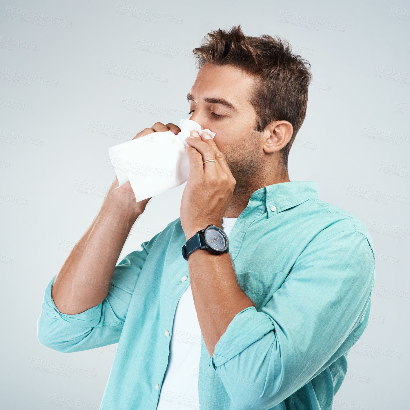 Buy stock photo Blowing nose, tissue and man in studio with allergy, sickness and virus infection on white background. Health, wellness and face of male person with handkerchief for hayfever, cold and sneeze for flu