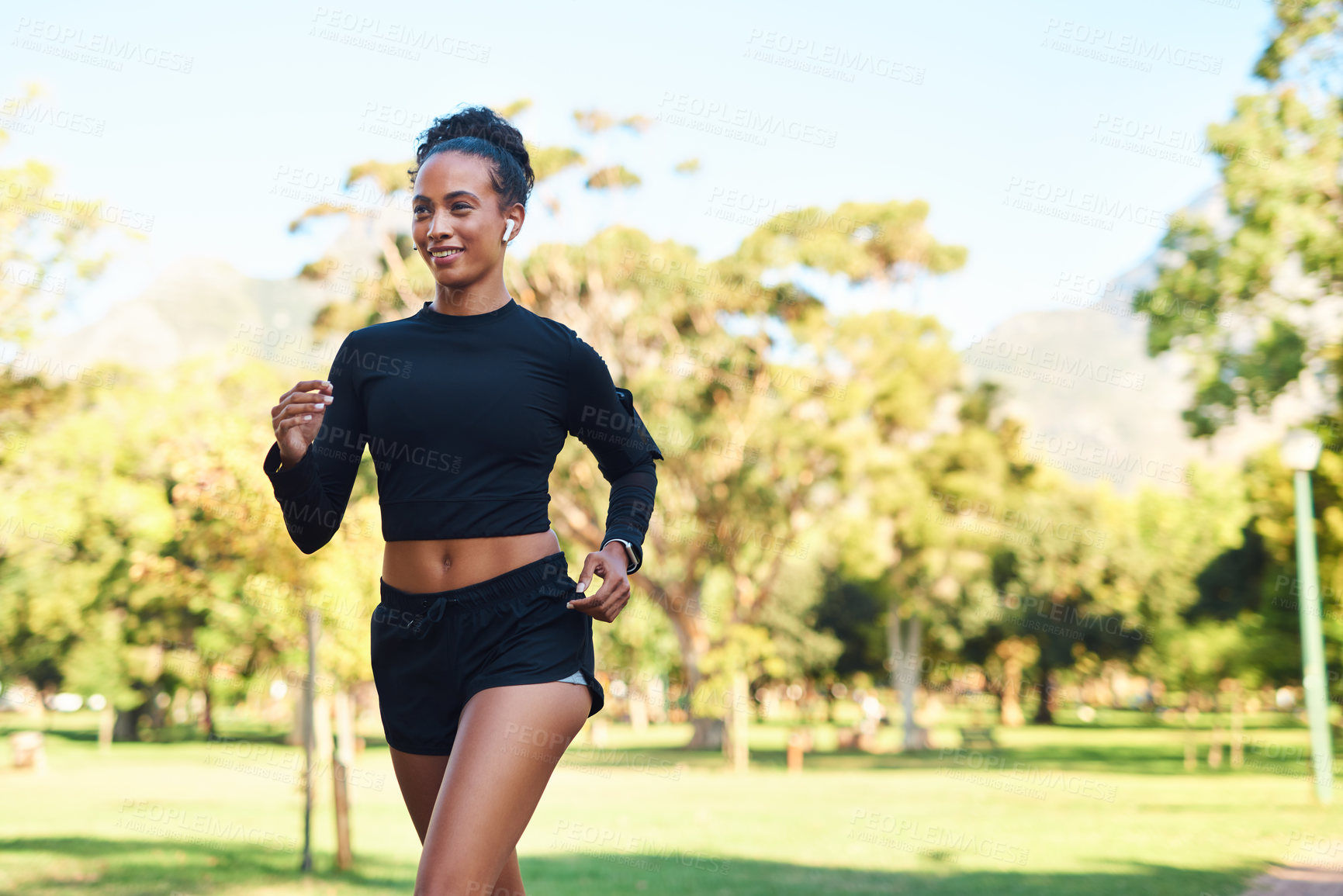 Buy stock photo Woman, park and happy with running for fitness with earphones for motivational music or audio in Atlanta. Female person, runner and smile or satisfied with exercise for health, wellness and self care