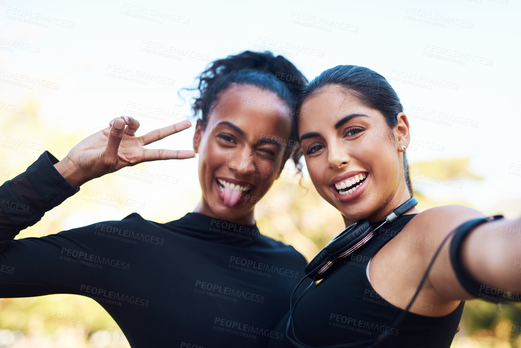 Buy stock photo Cropped portrait of two attractive young women posing for a selfie after their run together in the park