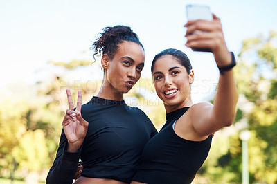 Buy stock photo Cropped shot of two attractive young women posing for a selfie after their run together in the park
