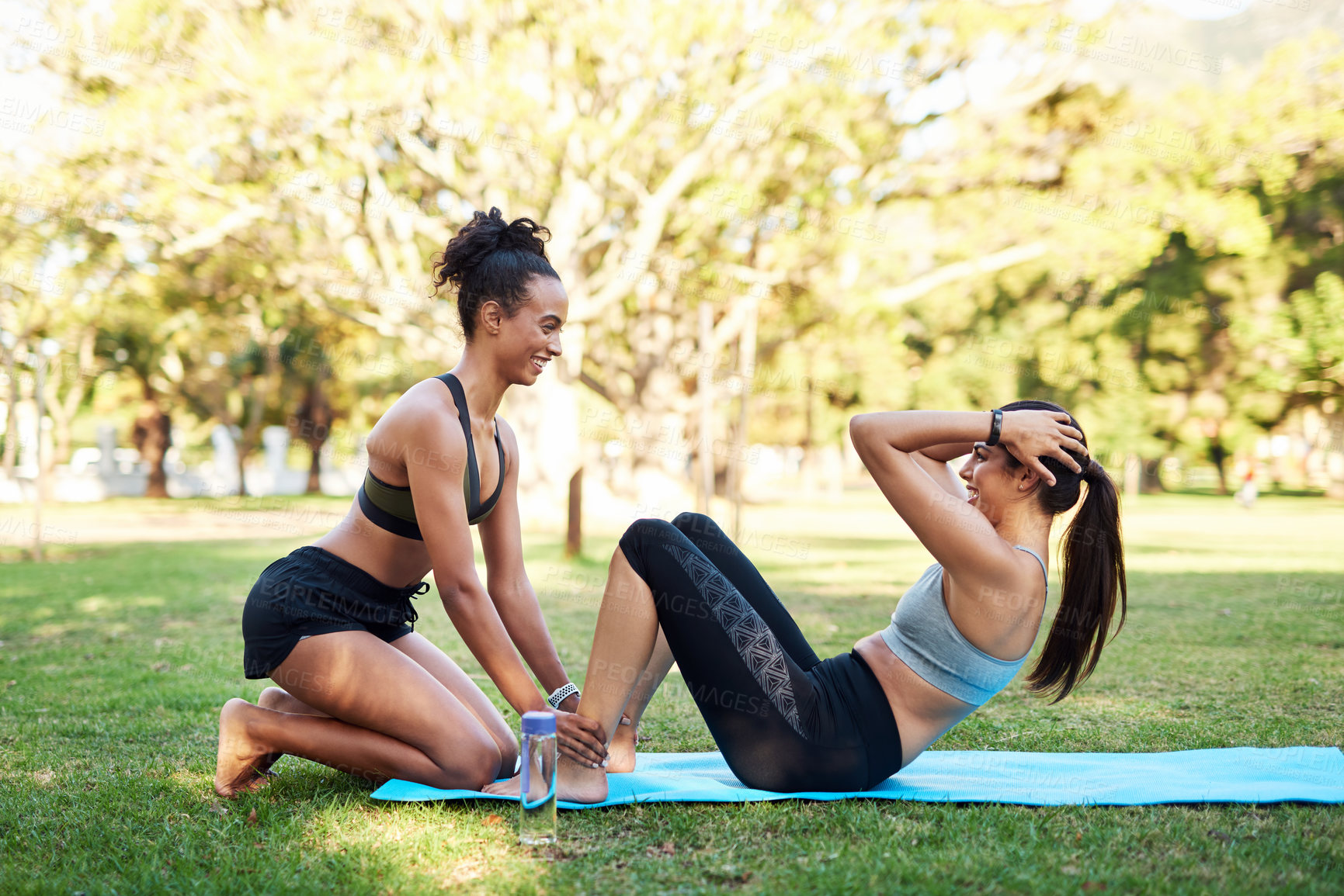 Buy stock photo Fitness, help or sit up with personal trainer and woman outdoor on field together for workout routine. Assistance, exercise and smile with friends in park for challenge, performance or training