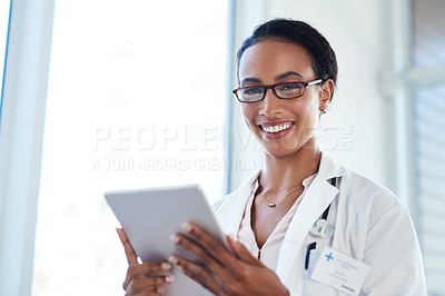 Buy stock photo Shot of a young doctor using a digital tablet in her consulting room