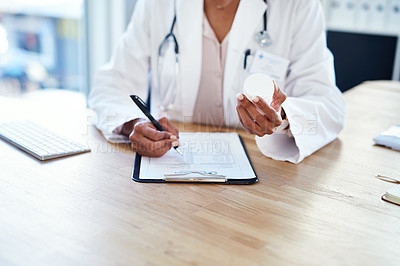 Buy stock photo Shot of a young doctor filling out a form for a prescription in her consulting room