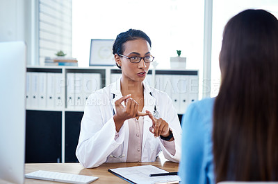 Buy stock photo Shot of a young doctor having a discussion with a patient in her consulting room