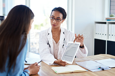 Buy stock photo Shot of a young doctor using a digital tablet during a consultation with her patient