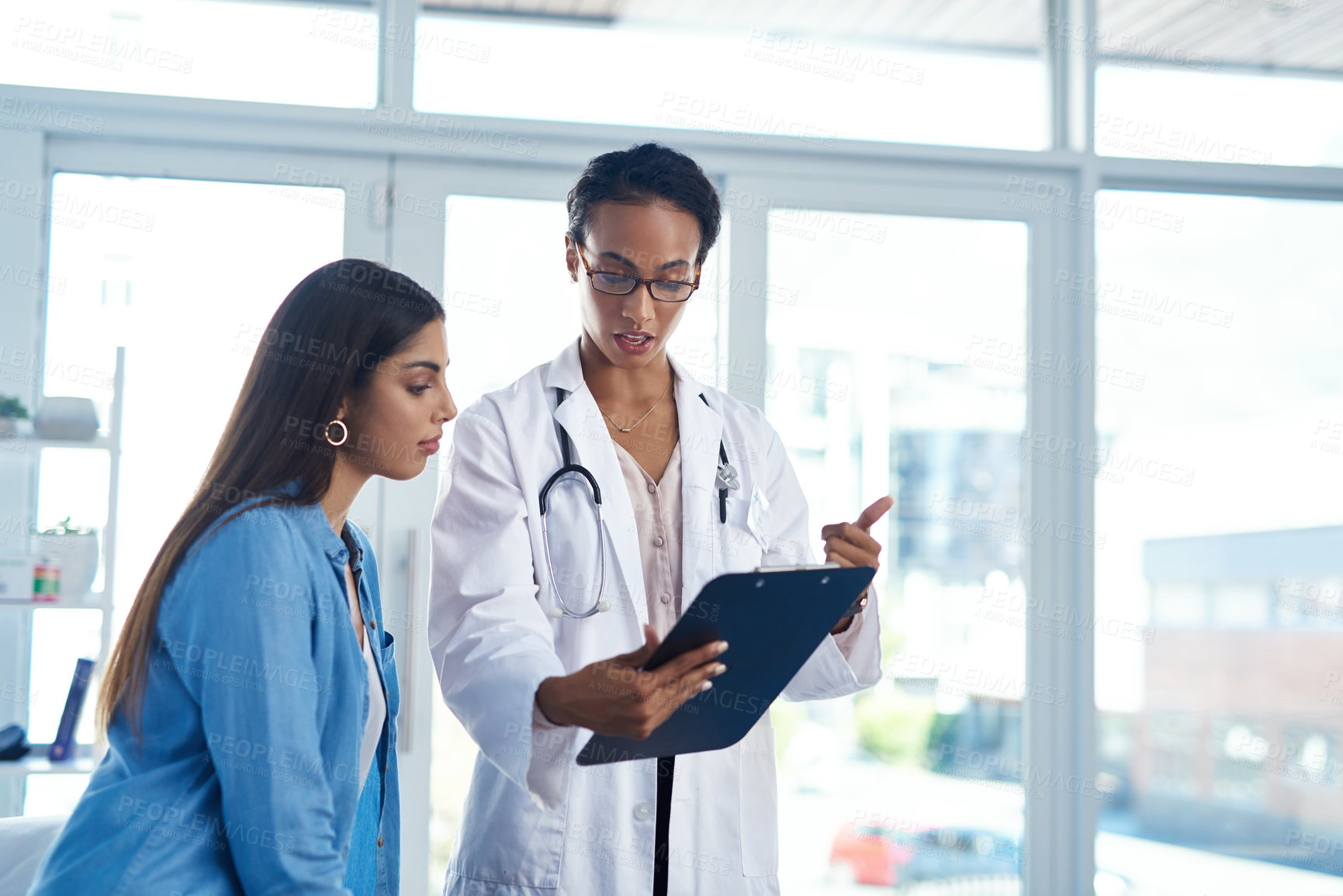 Buy stock photo Shot of a young woman having a consultation with her doctor