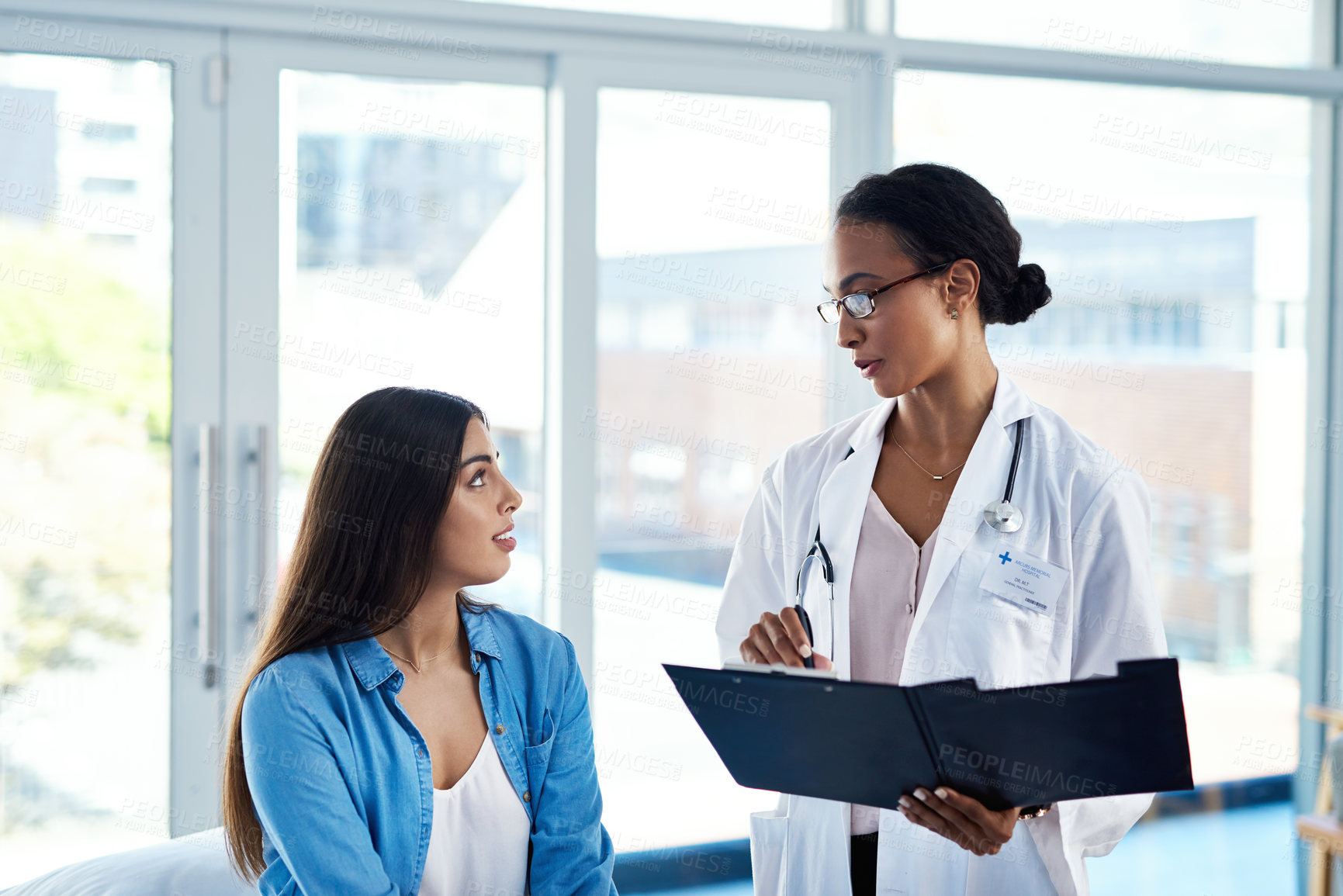 Buy stock photo Shot of a young woman having a consultation with her doctor