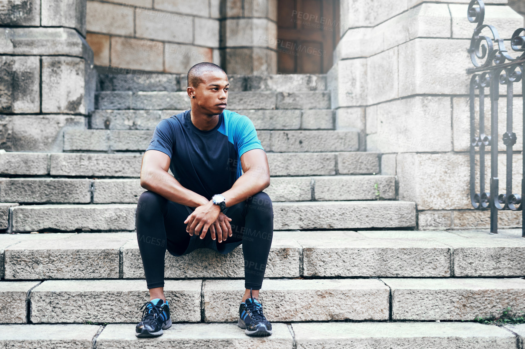 Buy stock photo Full length shot of a handsome young sportsman sitting down on a stairway outdoors in the city