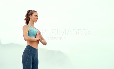 Buy stock photo Shot of a sporty young woman practicing yoga outdoors