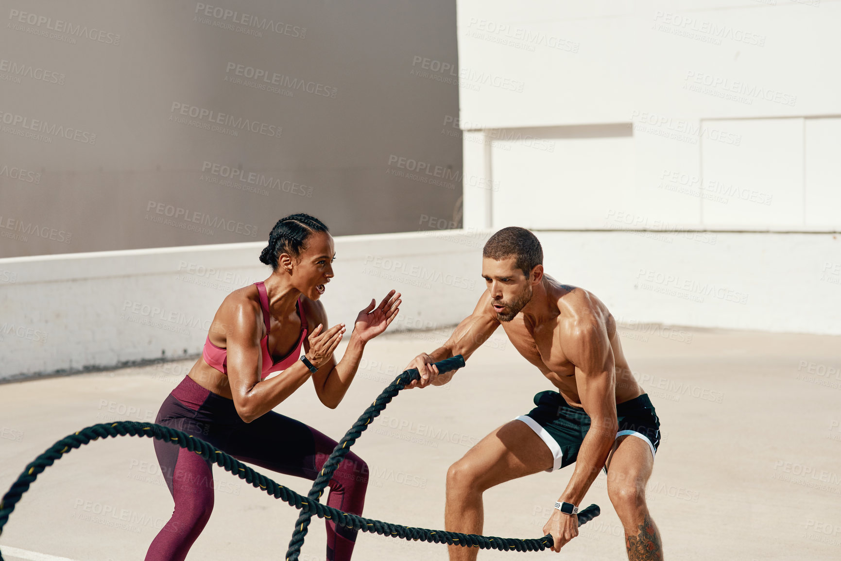 Buy stock photo Woman, personal trainer and battle rope training for workout, exercise or fitness outdoors. Fit, active or serious coaching with man person exercising with ropes for sports endurance or motivation