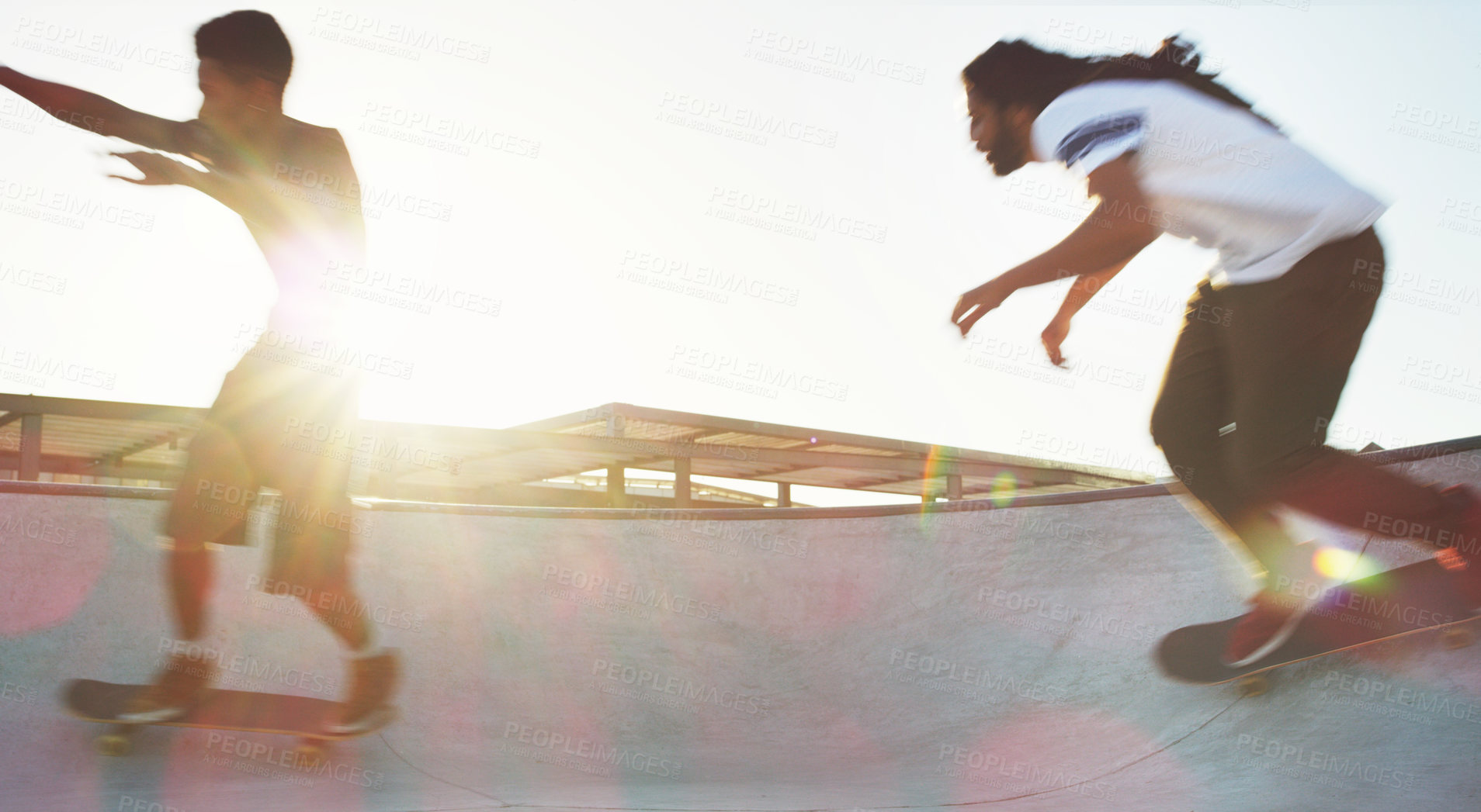 Buy stock photo Full length shot of two young men skating together on their skateboards at a skate park