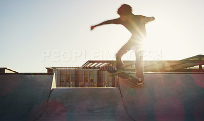 Buy stock photo Full length shot of a young man doing tricks on his skateboard at a skate park