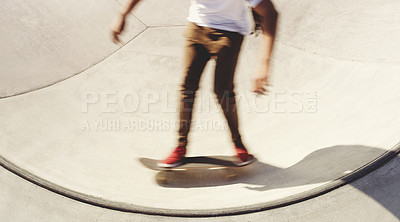 Buy stock photo Shot of an unrecognizable man doing tricks on his skateboard at a skate park