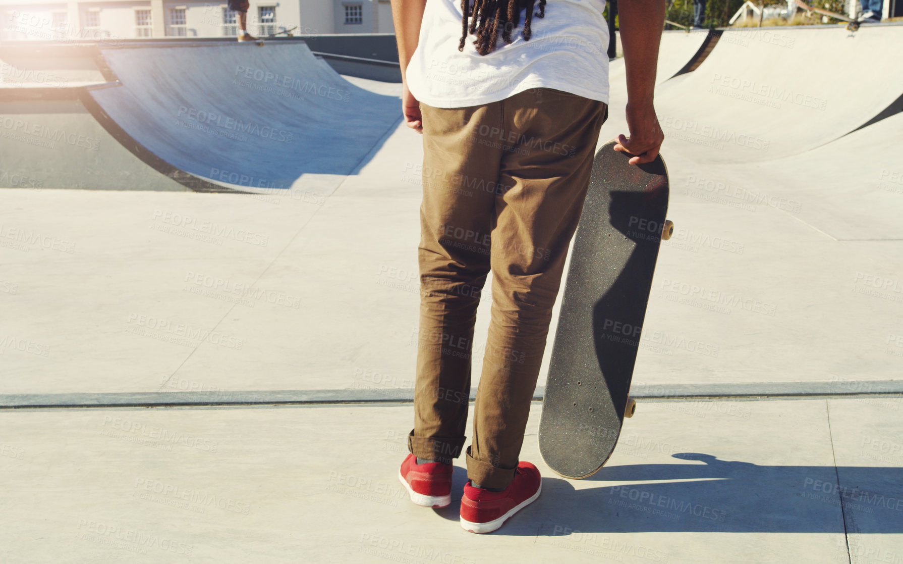 Buy stock photo Shot of an unrecognizable man doing tricks on his skateboard at a skate park