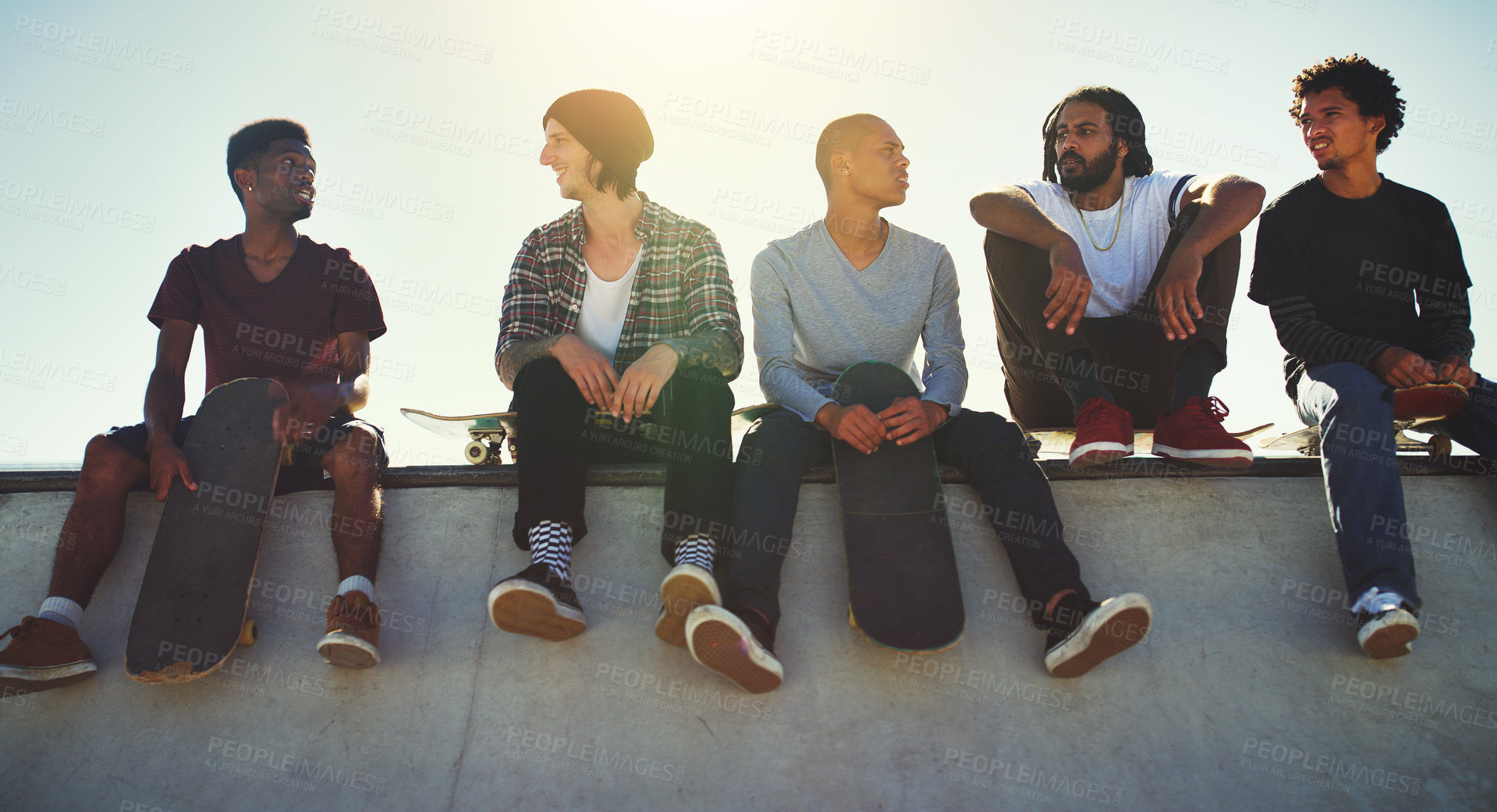 Buy stock photo Full length shot of a group of friends sitting together on a ramp at a skatepark