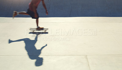 Buy stock photo Shot of an unrecognizable man doing tricks on his skateboard at a skate park