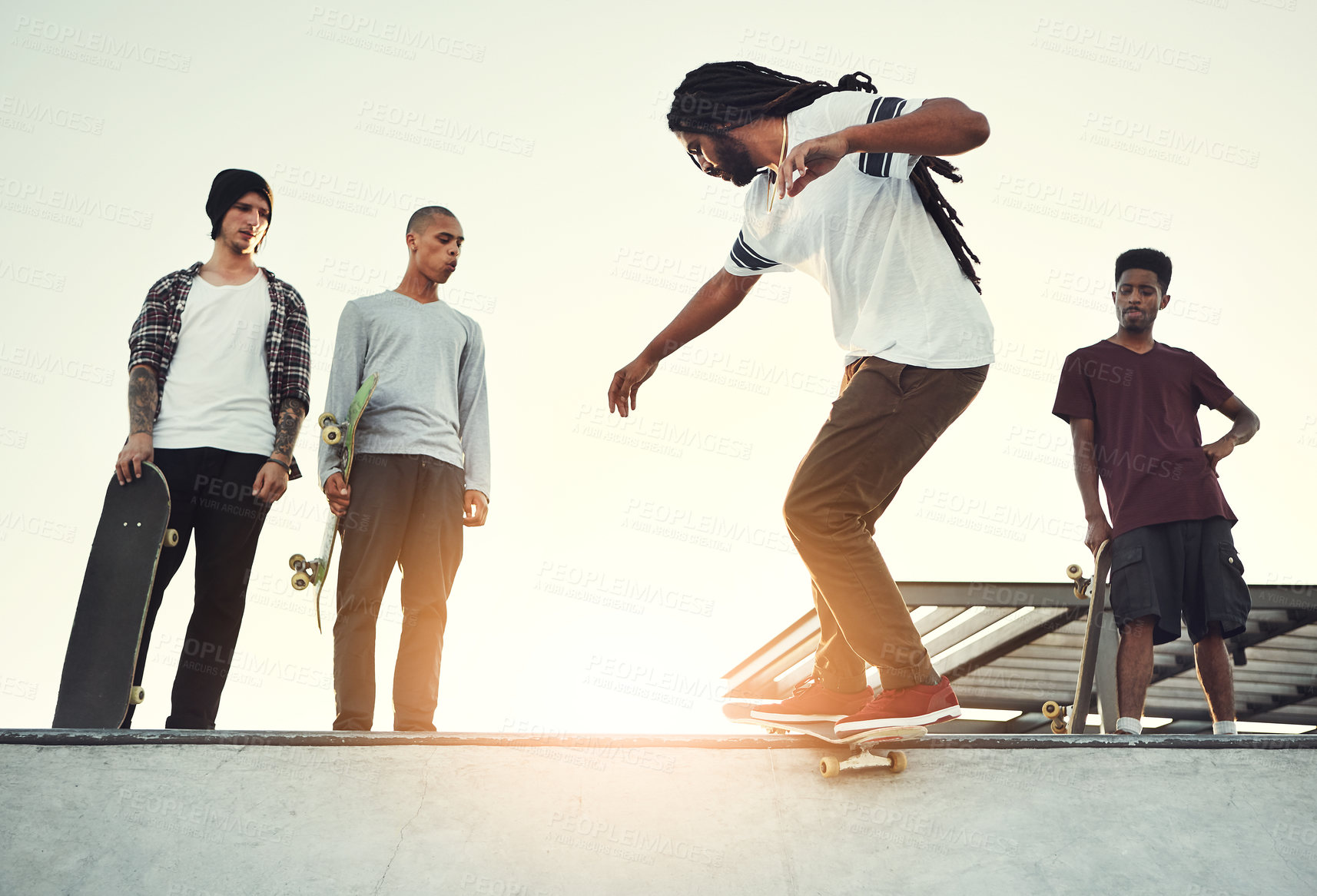 Buy stock photo Full length shot of a group of friends skating together on their skateboards at a skatepark