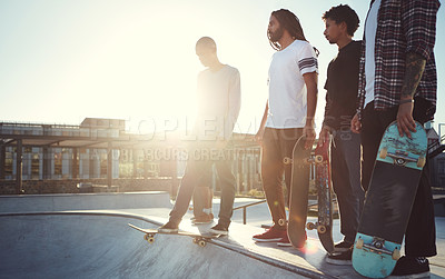 Buy stock photo Full length shot of a group of friends skating together on their skateboards at a skatepark