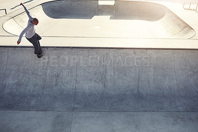 Buy stock photo High angle shot of a young man doing tricks on his skateboard at a skate park
