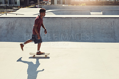 Buy stock photo Full length shot of a young man doing tricks on his skateboard at a skate park