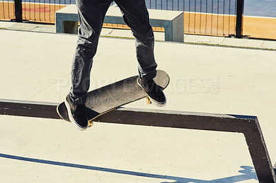 Buy stock photo Shot of an unrecognizable skater doing tricks on a steel rail with his skateboard outdoors