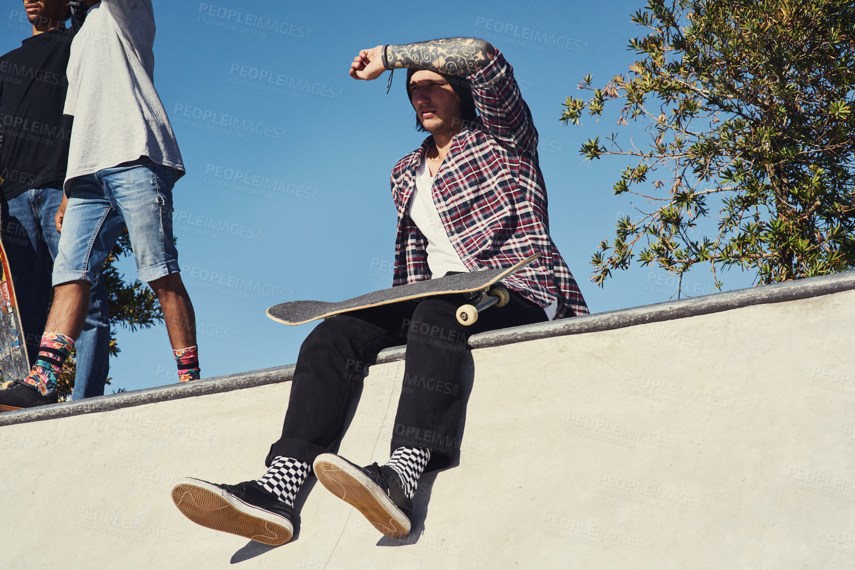 Buy stock photo Shot of a group of friends enjoying themselves at a skate park