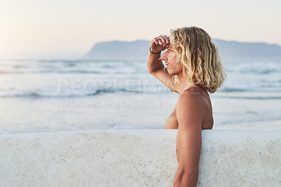 Buy stock photo Shot of a young surfer looking at the ocean waves before going surfing at the beach