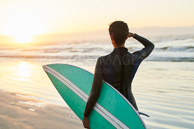 Buy stock photo Rearview shot of a female surfer looking at the ocean waves before going surfing at  the beach